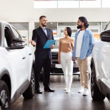 A,Well-dressed,Salesman,Is,Presenting,Information,To,Indian,Couple,In